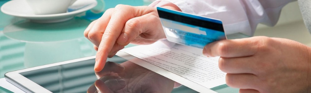 Man using credit card and tablet.