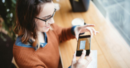 Lady scanning a check with phone.