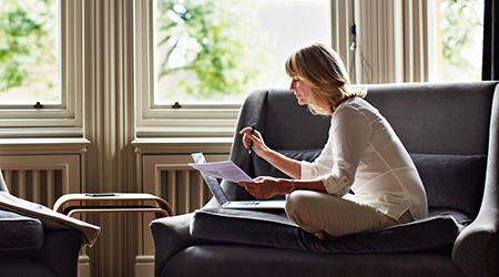 Woman doing paperwork in living room.