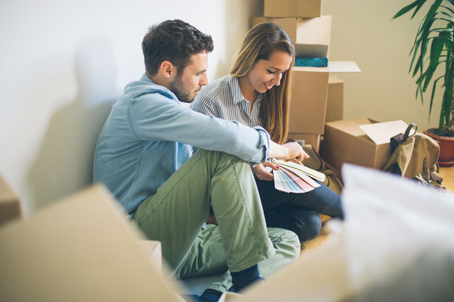 Young couple choosing paint in new house.